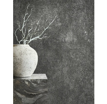 Gros plan d''un vase avec des branches devant un mur texturé sombre