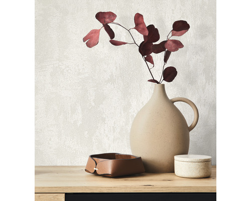 Arrangement décoratif avec vase, branches et boîtes de rangement sur une table.