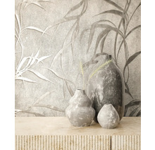 Vases décoratives grises sur une armoire décorée devant un papier peint à motifs