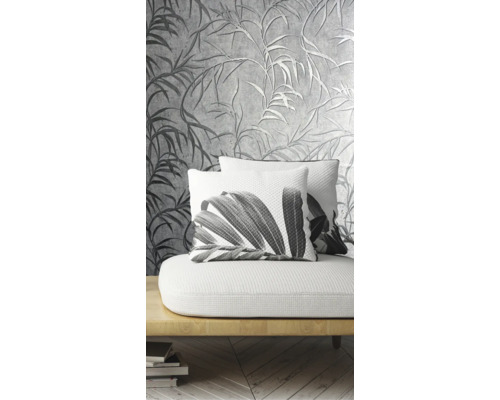 Salon décoratif avec un papier peint à motifs et des coussins à motifs végétaux sur un canapé