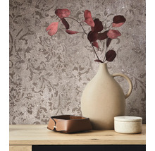 Nature morte décorative avec vase, bol et boîte devant un papier peint à motifs