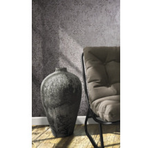 Vase décorative à côté d''une chaise devant un papier peint à motifs