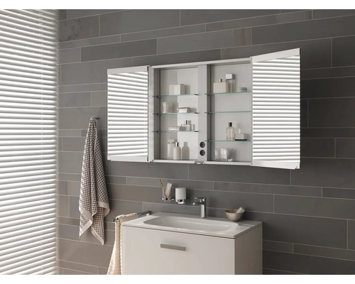 Salle de bains moderne avec armoire de toilette, lavabo et serviettes.