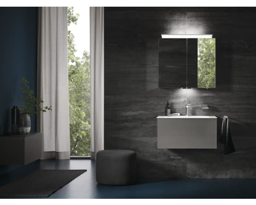 Salle de bains moderne avec lavabo, armoire de toilette et serviette