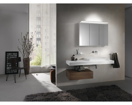 Salle de bains lumineuse avec lavabo, armoire de toilette et porte-serviettes