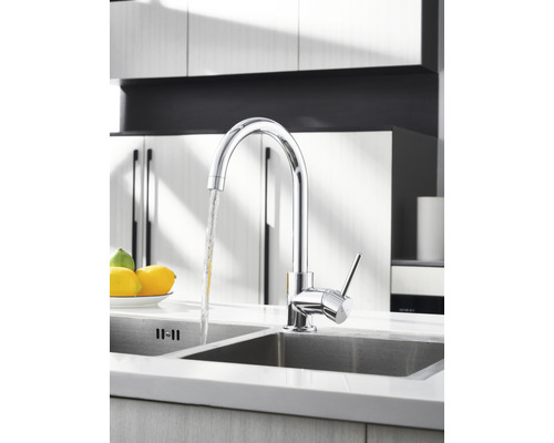 Küchenarmatur aus Chrom mit fließendem Wasser in einem Spülbecken