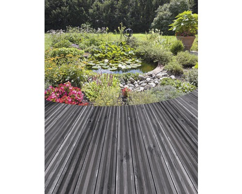 Gartenteich mit Seerosen und Blumen, angrenzend an eine Terrasse mit Holzdeck.