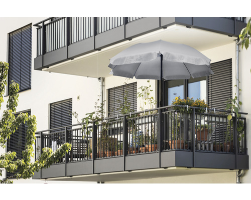 Balcon avec parasol et diverses plantes en pot.