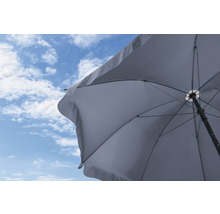 Geöffneter Sonnenschirm vor blauem Himmel mit Wolken