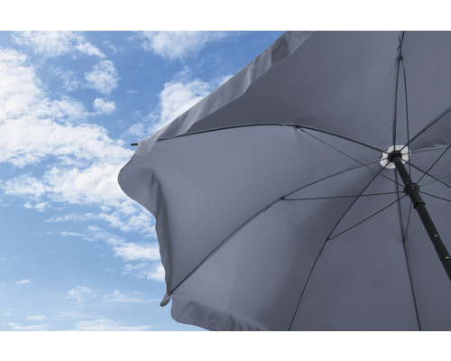 Parasol ouvert devant un ciel bleu avec des nuages