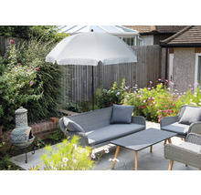 Ensemble de meubles de jardin avec parasol, canapé, fauteuils et table sur une terrasse.
