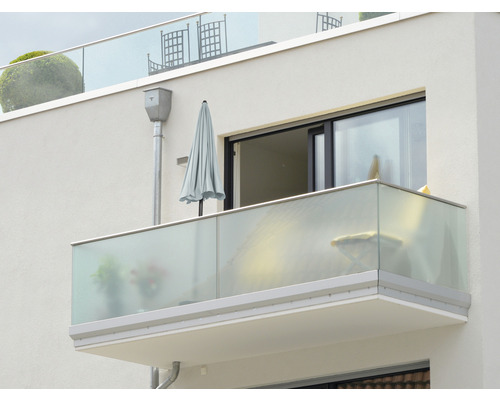 Vue extérieure d''un balcon avec balustrade en verre et parasol
