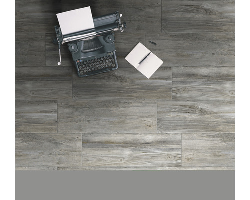 Graue Bodenfliesen in Holzoptik mit Schreibmaschine, Notizbuch und Stift