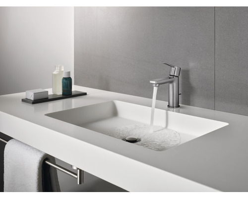 Lavabo de salle de bain moderne avec robinet et porte-serviettes.