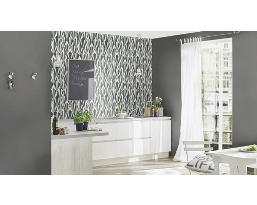 Küchenszene mit gemusterter Tapete, Küchenmöbeln und Dekorationen.