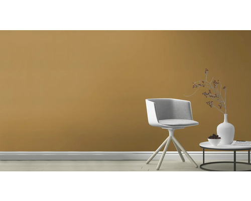 Szene mit einem Stuhl und einem Beistelltisch vor einer farbigen Wand