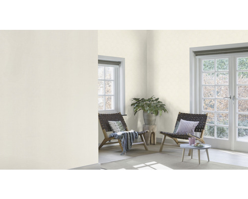 Heller Raum mit zwei Stühlen, Beistelltisch und Pflanzen dekoriert.