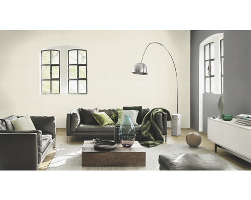 Wohnzimmer mit Sofa, Couchtisch, Stehlampe und hell gestrichener Wand