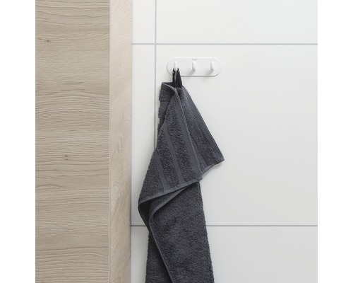 Serviette grise sur un crochet au mur