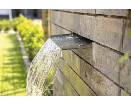 Gartenbrunnen mit Wasserspiel an Steinmauer