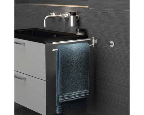 Salle de bains avec lavabo, robinet, porte-serviettes et serviette.