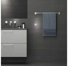 Salle de bains moderne avec meuble sous-lavabo, robinetterie, porte-serviettes et serviette.