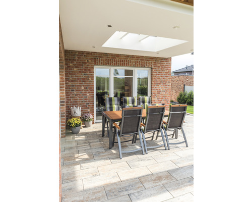 Groupe de sièges de jardin sur terrasse pavée avec mur de briques