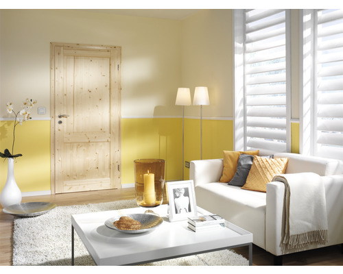 Salon avec porte en bois, canapé et fenêtres à lamelles pour une ambiance lumineuse et chaleureuse.