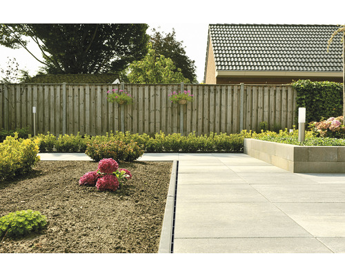 Garten mit Pflastersteinen, Blumen und Holzzaun