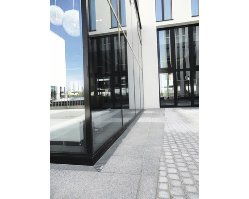 Aussenansicht eines modernen Gebäudes mit Glasfassade und gepflastertem Gehweg