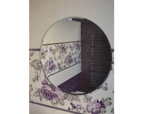Miroir rond dans une salle de bains avec des carreaux muraux à motifs floraux