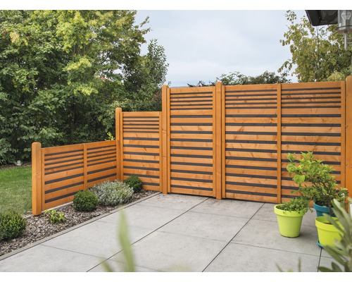 Scène de jardin avec clôture en bois à lattes horizontales sur une terrasse.