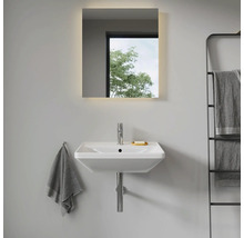 Modernes Badezimmer mit Waschbecken, beleuchtetem Spiegel und Handtuchhalter.