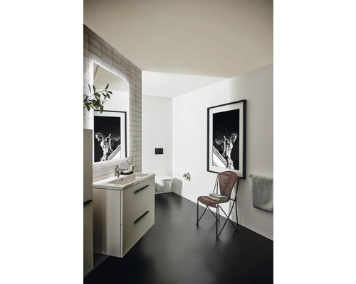 Salle de bains lumineuse avec meuble-lavabo, miroir, toilettes, chaise et décoration