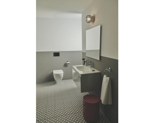 Salle de bain moderne avec toilettes, lavabo, miroir et tabouret rouge