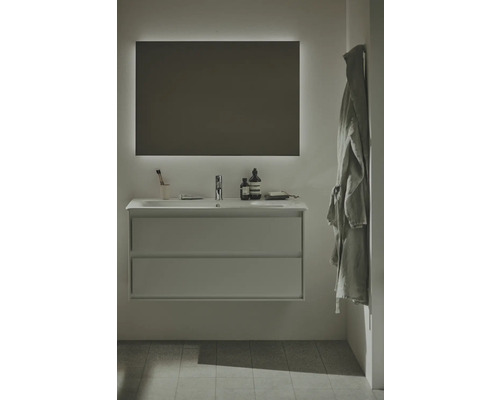 Salle de bains moderne avec meuble sous-lavabo, lavabo, miroir éclairé et peignoir