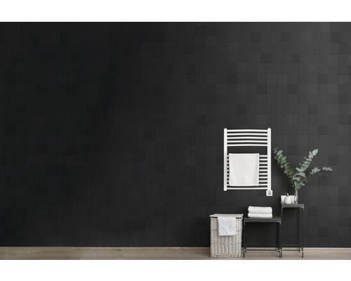 Salle de bains moderne avec carrelage noir, sèche-serviettes, panier à linge et décoration