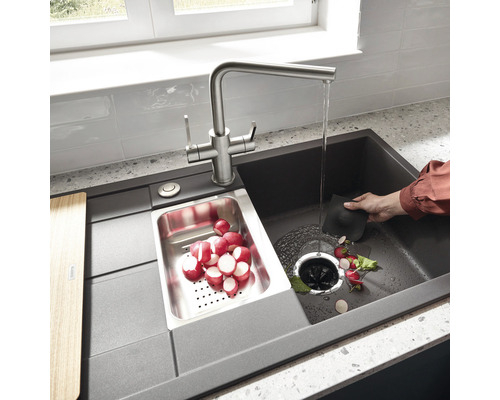 Spüle mit Abtropffläche, Armatur und Gemüseschale im Einsatz.
