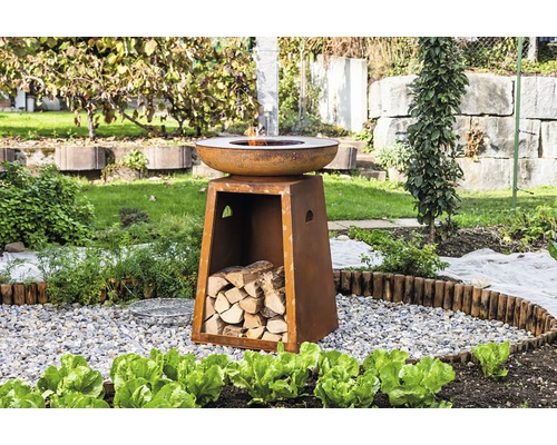 Feuerstelle aus Metall mit Holzfach im Garten.