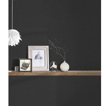 Articles décoratifs sur une étagère en bois devant un mur sombre