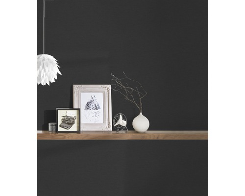 Articles décoratifs sur une étagère en bois devant un mur sombre