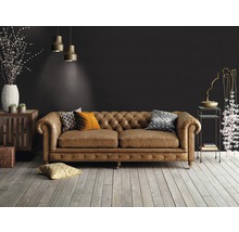 Salon avec un canapé en cuir marron de style Chesterfield, parquet en bois et éléments décoratifs