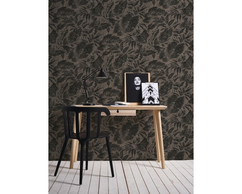 Un bureau avec un papier peint à motifs, un bureau, une chaise et une lampe de bureau.