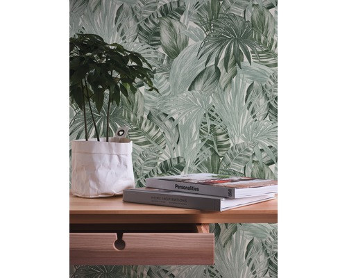 Décoration murale avec papier peint motif feuilles, bureau avec plante et livres