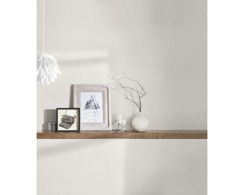 Ambiance d''intérieur avec étagère en bois, éléments de décoration tels que cadres, vase avec des branches et lampe en papier