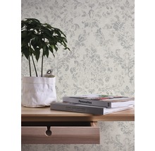 Wandgestaltung mit Ornamenttapete, Tisch mit Dekoration und Zimmerpflanze.