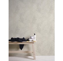 Badezimmer mit Tapete mit Palmenmuster, Handtuch und Pflegeprodukten auf einer Bank