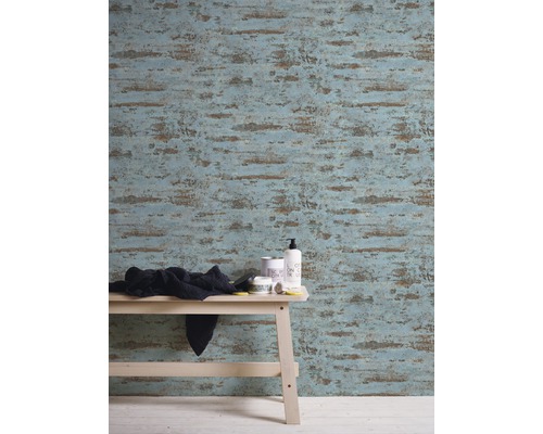 Vue d''une pièce avec papier peint à motifs, tabouret en bois clair et accessoires de salle de bain