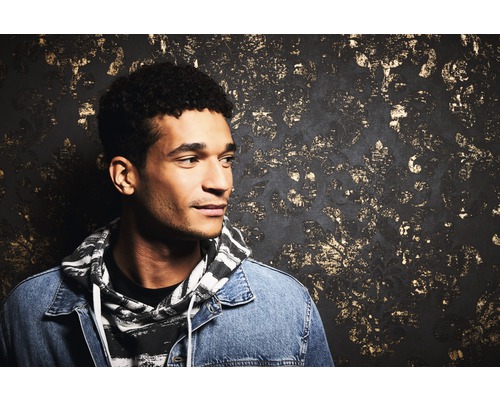 Porträt eines Mannes vor einer dekorativen Wand