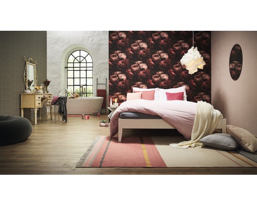 Schlafzimmer mit Bett, Teppich, Badewanne und Waschtisch.